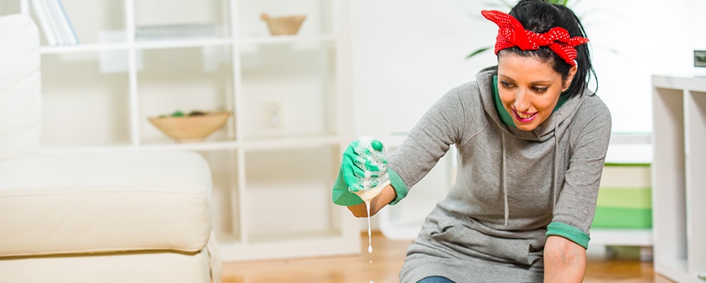 young woman squeezing soapy water from sponge