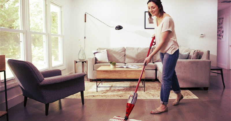 smiling woman mopping the floor