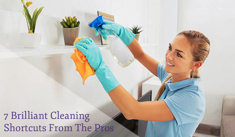 happy woman in blue top wiping a shelf