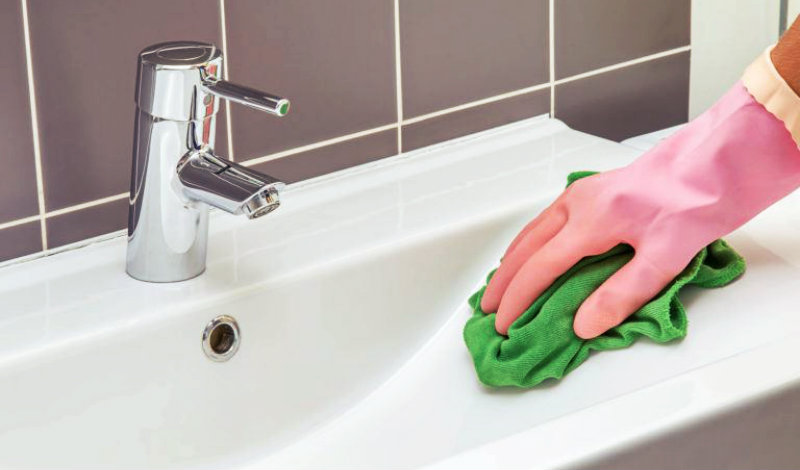 cropped image of a woman wiping washbasin