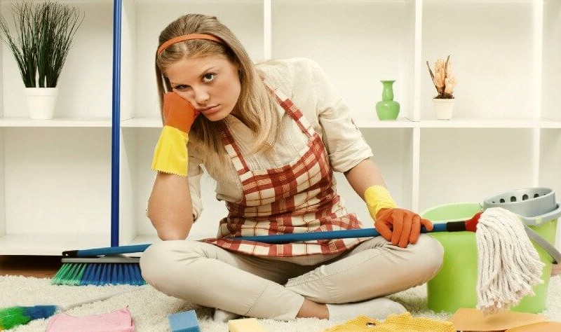 stressed woman sitting on the floor with having a mop on her lap
