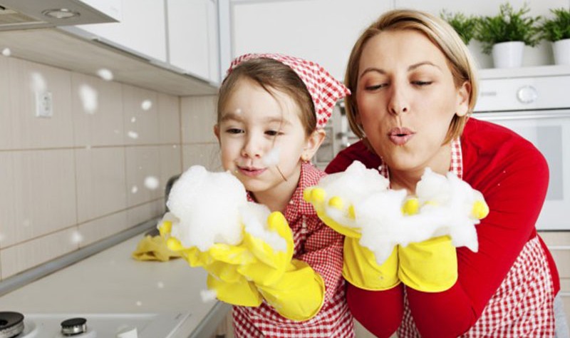 happy mother and daughter playing with soap bubbles