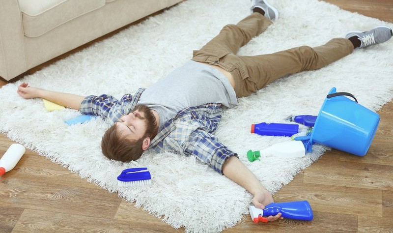 a tired man is laying on a carpet