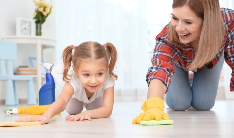 a mother is moping the floor with her daughter