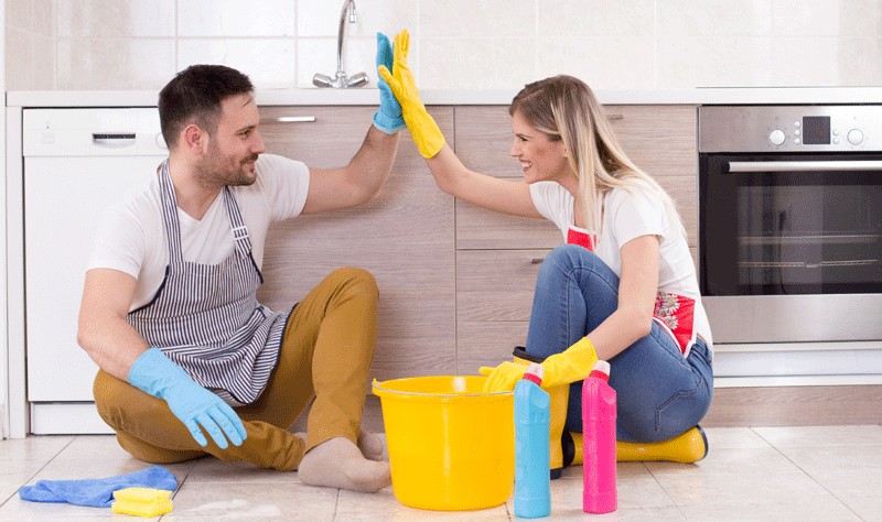 a happy couple sitting on the floor in their kitchen