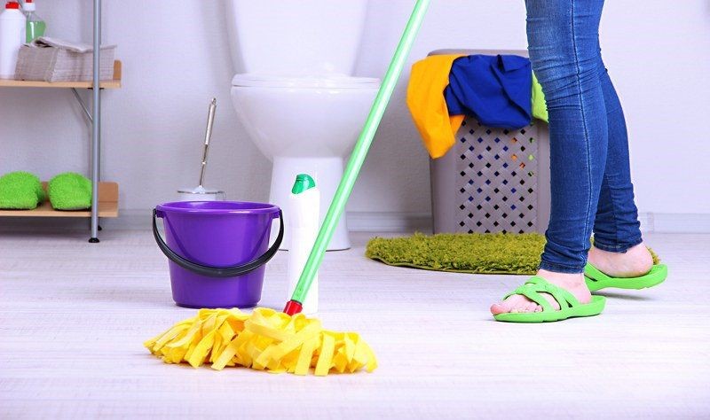 cropped image of a woman wiping the bathroom floor with a wiper
