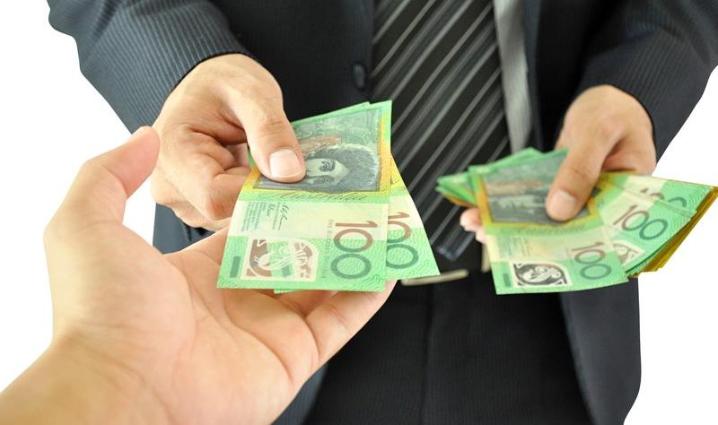 cropped image of two person exchanging Australian currency