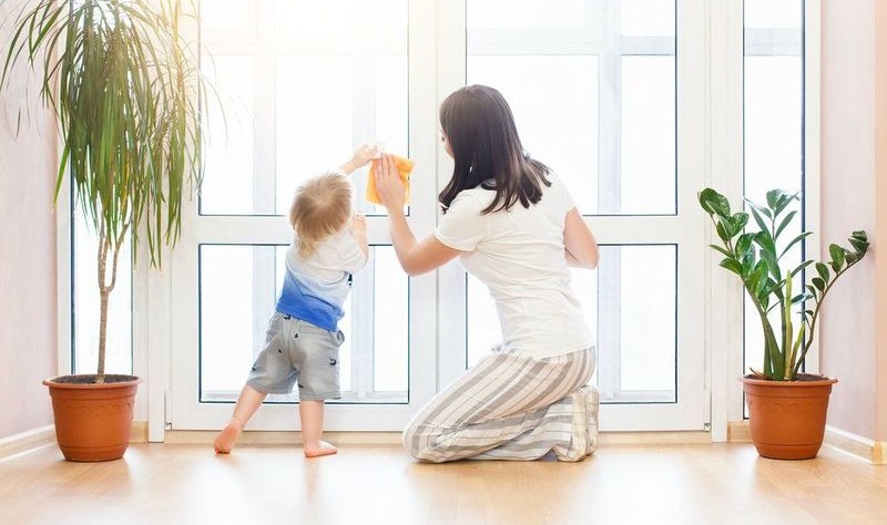 woman wiping the door with her child