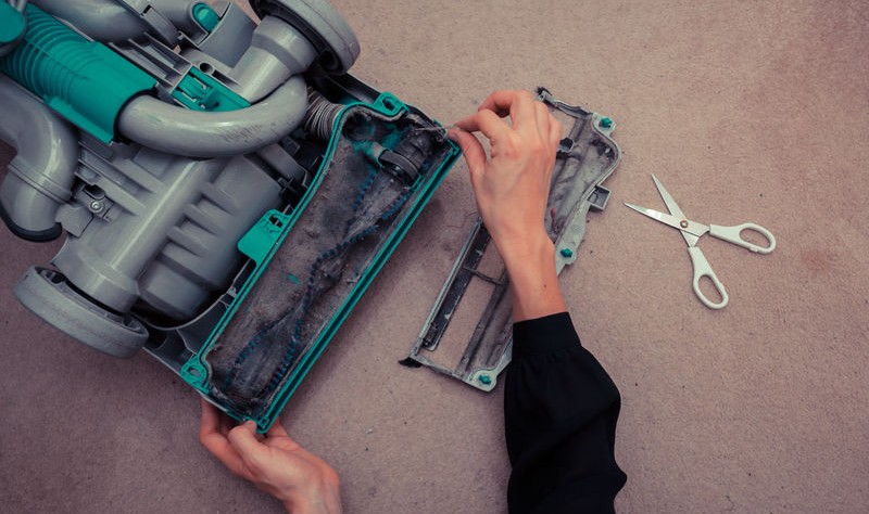 cropped picture of a woman repairing a vacuum cleaner