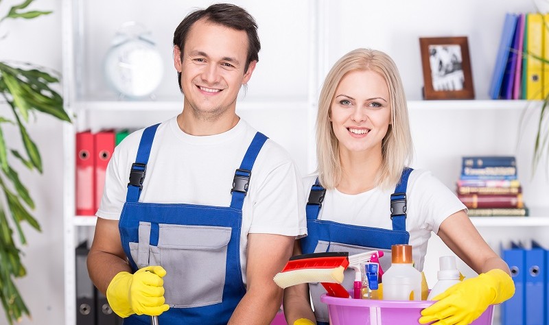 young professional couple with a basket full of chemical bottles and spray bottles