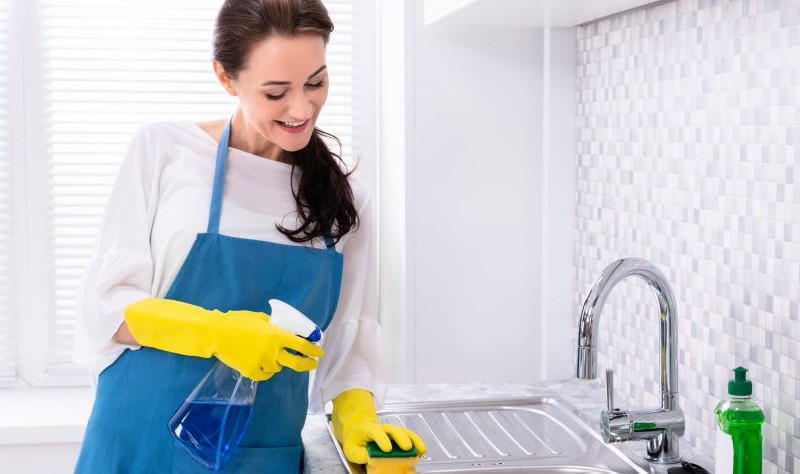 young woman sprucing up a kitchen
