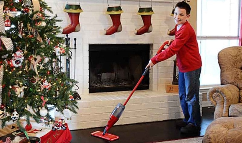 young boy sprucing a house for christmas