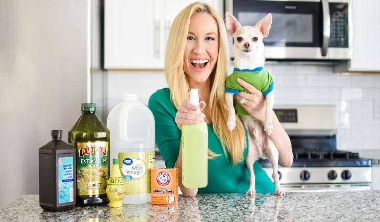 Woman holding a bottle in one hand and her dog in second hand