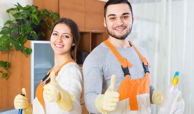 One woman and one man showing their thumbs up and holding a white bottle in hand.