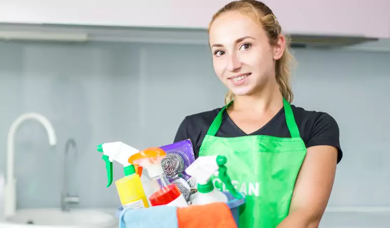 young woman with a bucket full of cleaning supplies