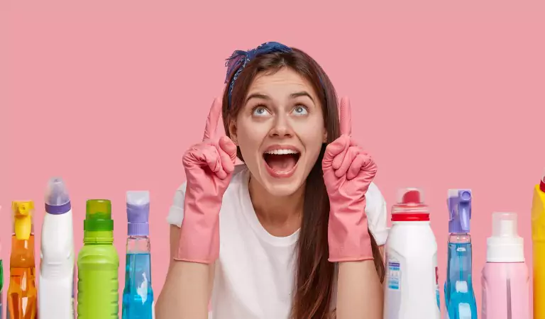 woman looking happy and sitting with some cleaning supplies