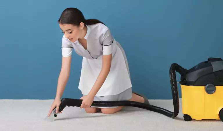young woman vacuuming a carpet