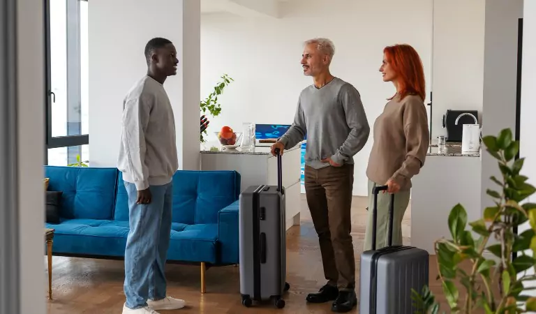 young man welcoming guests inside of his house