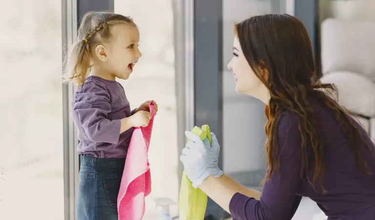 Woman with her daughter with some cleaning essentials ready for cleaning