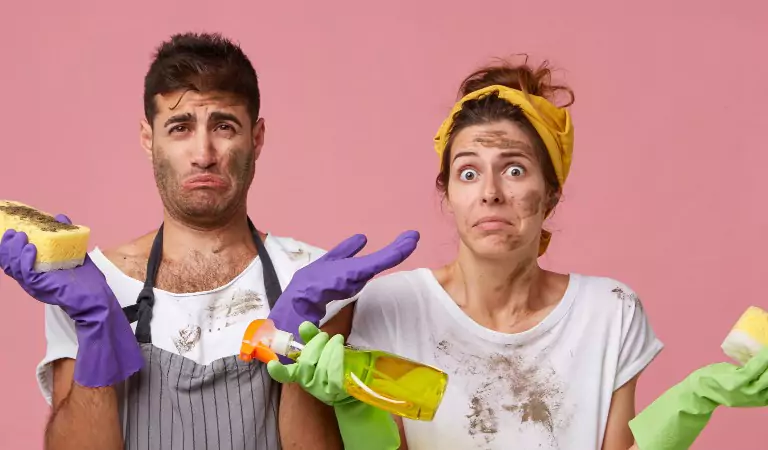 couple looking helpless while cleaning their house