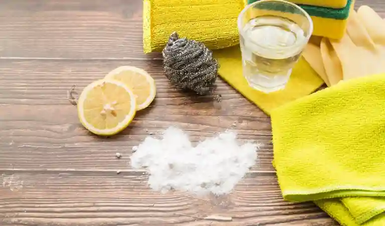 Lady cleaning clogged drain inside a kitchen
