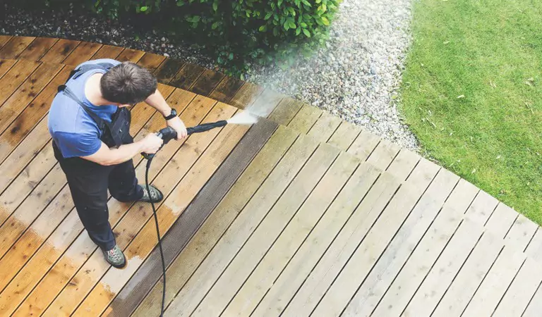 young man cleaning outdoor surfaces of house