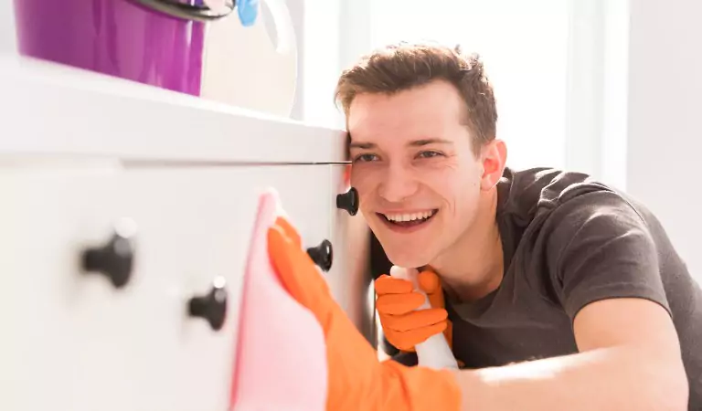 young man cleaning a household surface