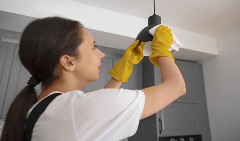 woman cleaning light Fixtures