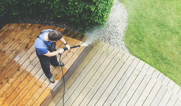 young man cleaning outdoor with pressure water