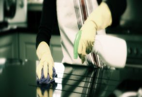 cropped image of a woman wiping kitchen counter