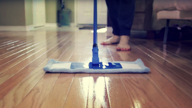 cropped image of a woman mopping hardwood floor