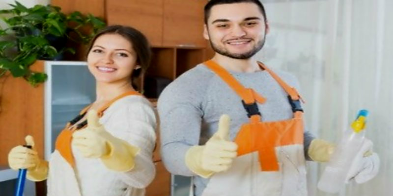 man and woman in orange apron showing thumbs up and wearing protective gloves