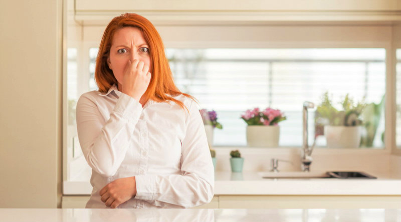 beautiful woman getting irritated from musty smell