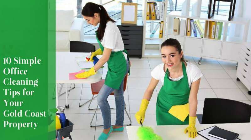 two women wearing green aprons wiping office space