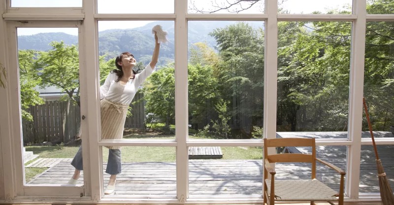 woman on-patio cleaning glass windows from outside