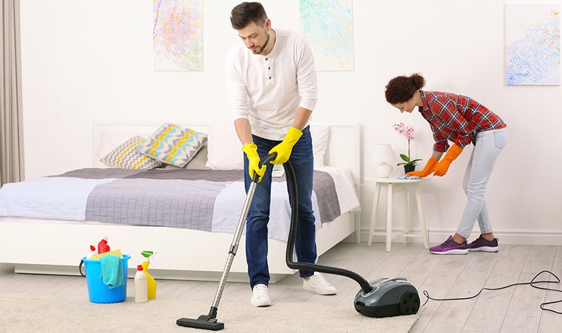 A couple is cleaning their room