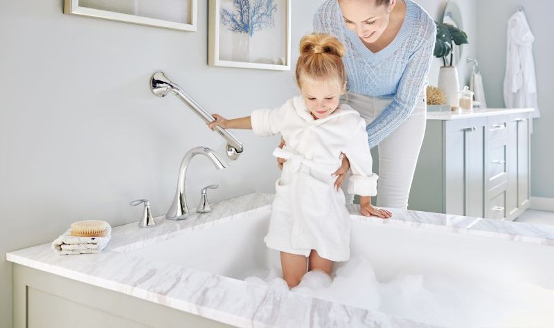 A mom and a doughter is enjoying in a bathtub