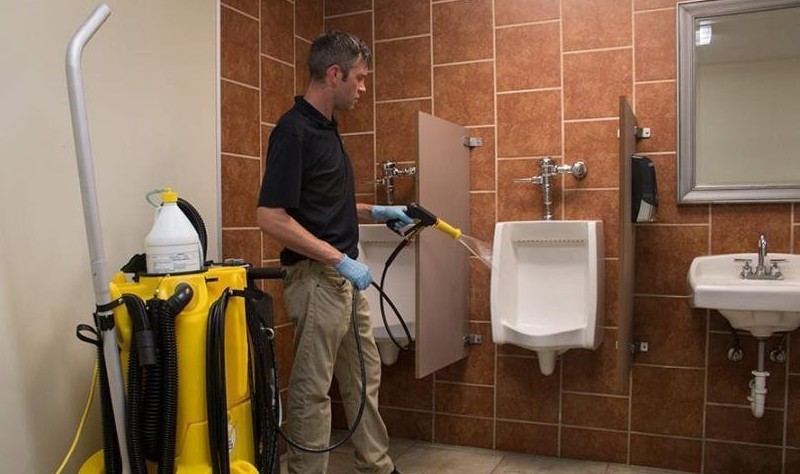 a guy is cleaning a restroom