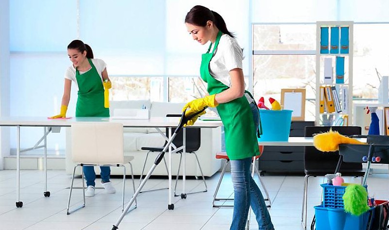 Beautiful girls are cleaning office
