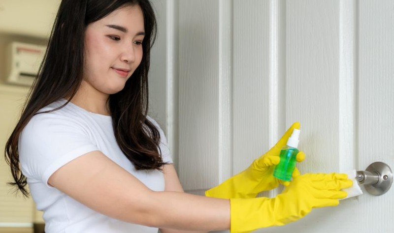 a woman is cleaning doorknob