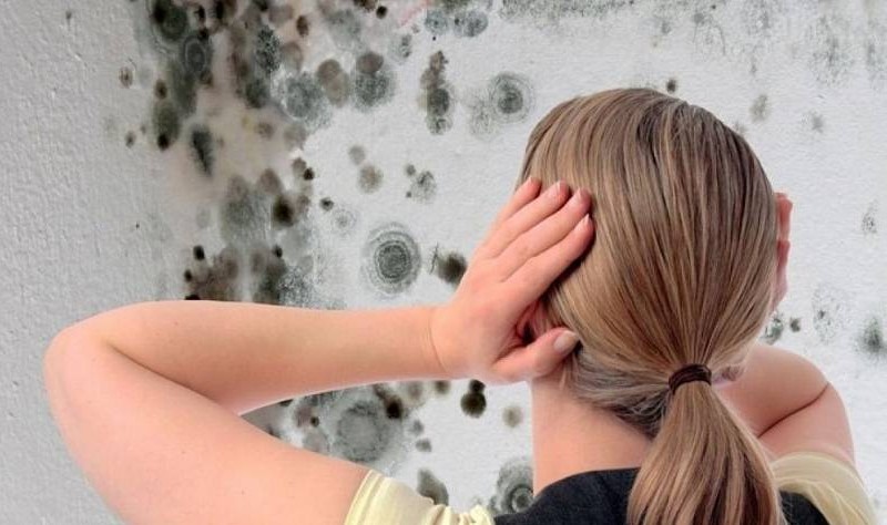 young woman looking tensed about mould growth inside her house