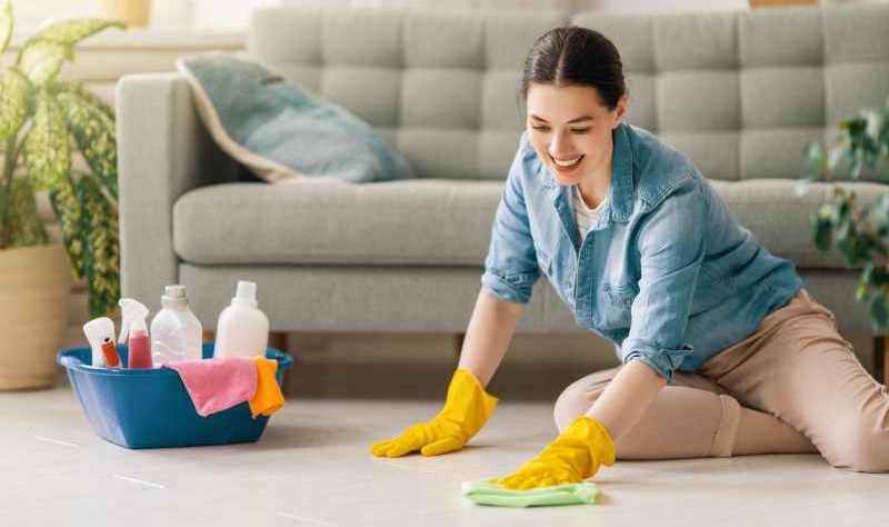 a woman wiping the floor with a cloth mop