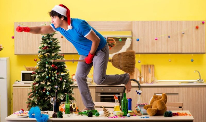 young man wearing a Christmas hat preparing to spruce up his house