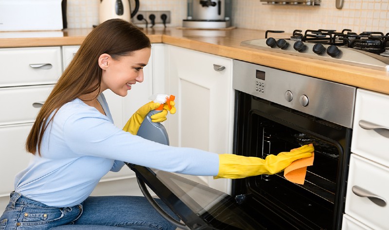 a girl is cleaning microwave
