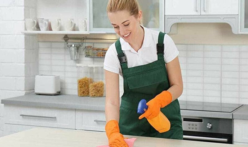 young professional disinfecting a kitchen surface