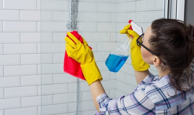 young woman sprucing up the bathroom tiles