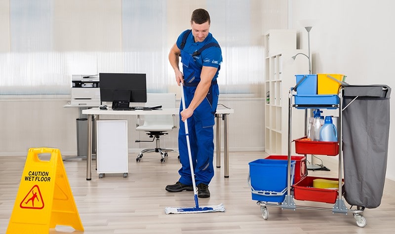 young professional moping the floor of a commercial property
