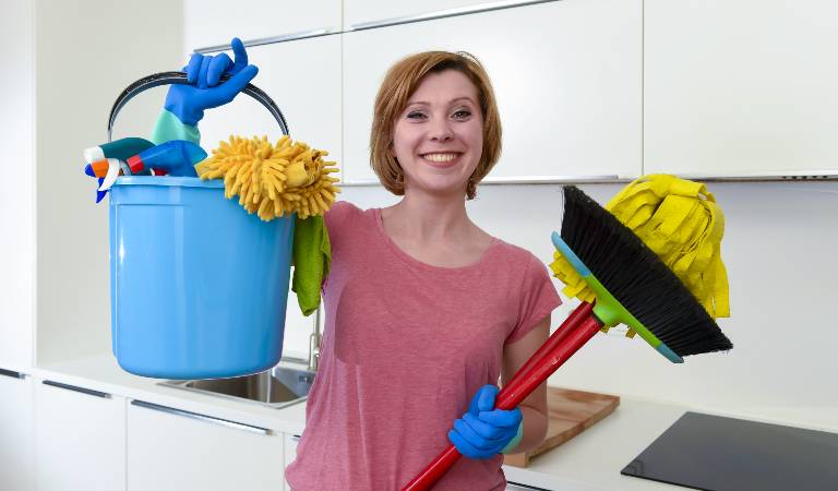 Woman in marron top holding a blue basket and red stick in her hand