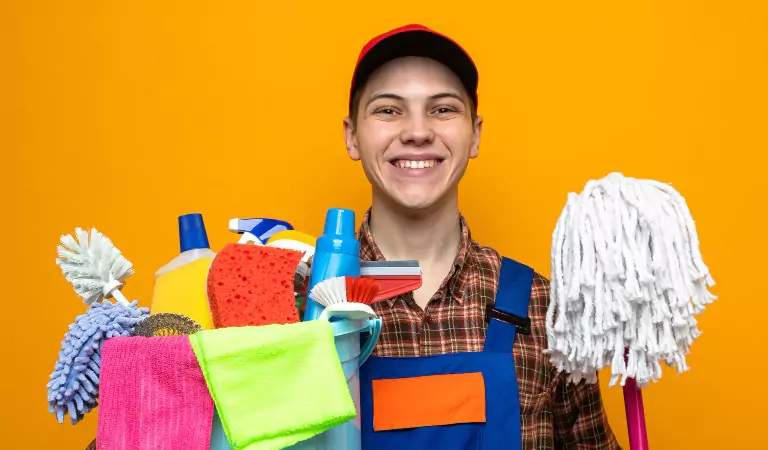 young professional with some cleaning essentials ready to clean