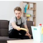 Low angle man on break from cleaning on couch